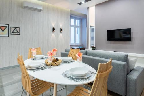 ein Esszimmer mit einem weißen Tisch und Stühlen in der Unterkunft Modern 2 bedroom apartment with free airport transfer in Budapest