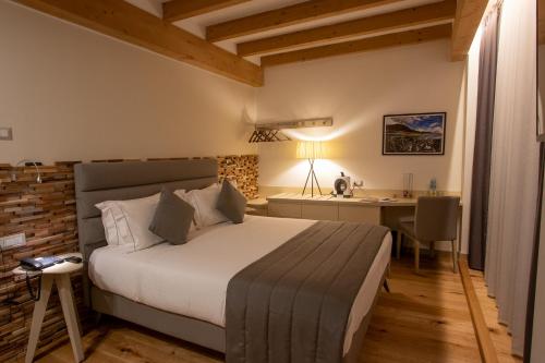 a bedroom with a bed and a desk in a room at Lifestyle Room Binario Zero in Tirano