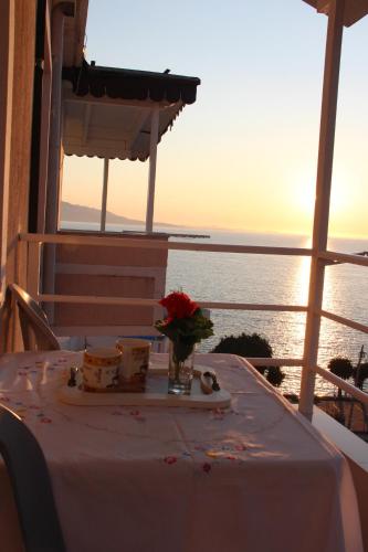 Mejdi Apartments في سارنده: طاولة عليها مفرش أبيض وأزهار