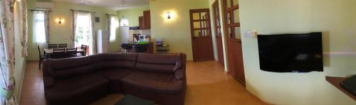 a living room with a couch and a flat screen tv at Trou Aux Biches Self Catering Apartment in Trou aux Biches