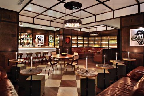 un restaurante con mesas y sillas y un bar en Gild Hall, A Thompson Hotel, by Hyatt, en Nueva York