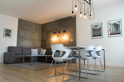 a living room with a table and white chairs at Silver Apartments in Wrocław