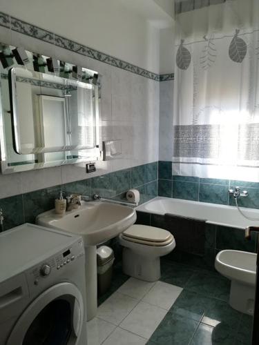 a bathroom with a sink toilet and a washing machine at Appartamento Bellavista in Moneglia