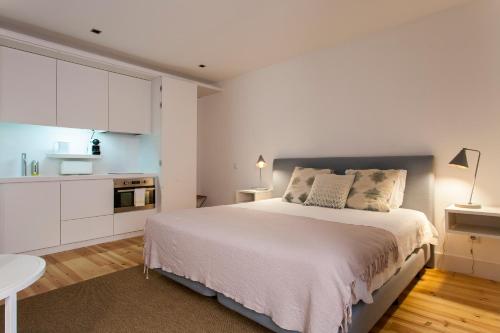 a hotel room with a white bed and white walls at Lisbon Five Stars Apartments Combro 77 in Lisbon