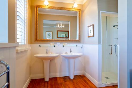 a bathroom with two sinks and a mirror at St Leonards Lodge in Dunedin