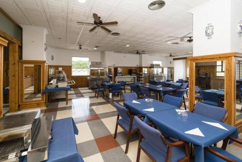 un comedor con mesas azules y sillas azules en Hotel Carabela Santa María, en Mazagón