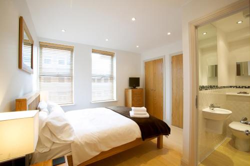 紐伯里的住宿－2 bed 2 bath at Pelican Hse in Newbury - FREE secure, allocated parking，一间卧室配有床、水槽和卫生间