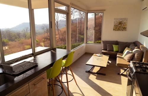 cocina y sala de estar con ventanas grandes y sofá en Horizon Lodge Potrero, en Potrero