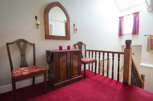 a room with two chairs and a mirror on the wall at Victoria House Room Only Accommodation in Caernarfon