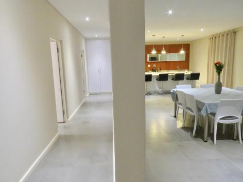 a dining room and kitchen with a white table and chairs at The Executive - Exclusive Self-Catering Apartments - Ezulwini in Ezulwini