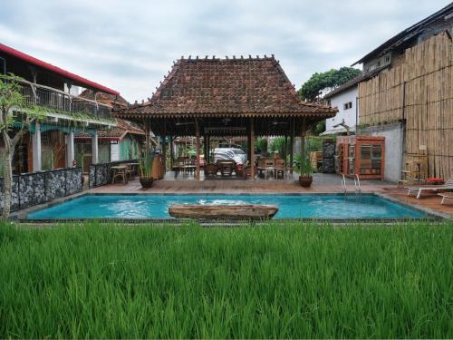 une maison avec une piscine et un kiosque dans l'établissement Kampung Lawasan Heritage Cottage, à Yogyakarta