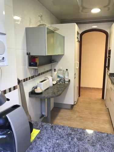 a small kitchen with a counter and a hallway at Amazing in front of the sea apartment in Comarruga