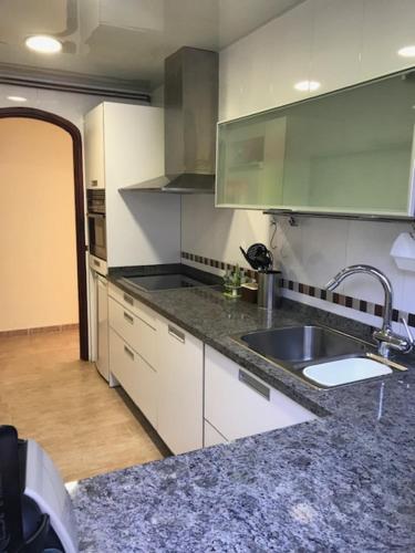 a kitchen with a sink and a counter top at Amazing in front of the sea apartment in Comarruga
