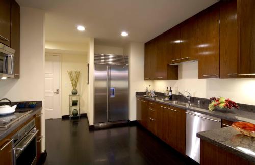 a kitchen with wooden cabinets and a stainless steel refrigerator at Trump International Hotel Las Vegas in Las Vegas