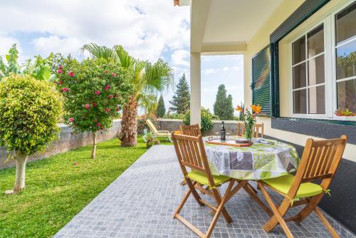 a patio with a table and chairs on a house at Casa Ventura in Arco da Calheta