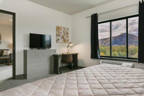 a bedroom with a large bed and a large window at Silver Creek Hotel in Hailey