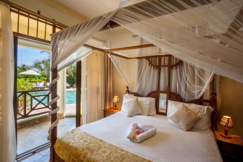 a bedroom with a canopy bed with a view of the ocean at Amani Luxury Apartments in Diani Beach