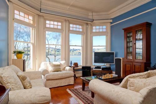 a living room with two couches and a tv at St Leonards Lodge in Dunedin