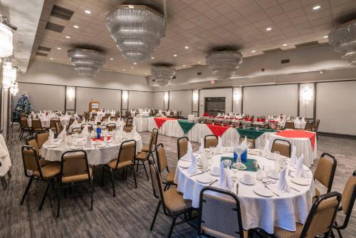 a banquet hall with white tables and chairs at Ramada by Wyndham Thunder Bay Airlane Hotel in Thunder Bay