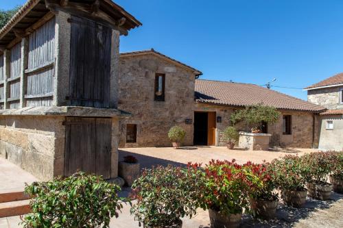 an old stone building with plants in front of it at Casa Rural as Bentinas in Milladoiro