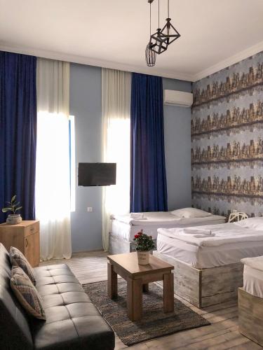 a hotel room with two beds and a couch at Check Point Hotel in Tbilisi City