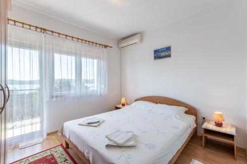 1 dormitorio con cama y ventana grande en Apartments Mimi, en Trogir
