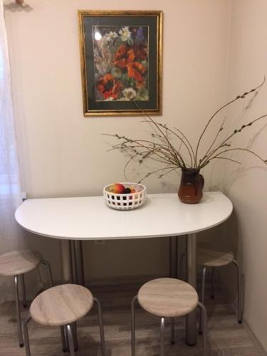 a table with a bowl of fruit and a vase on it at 9 Mežmalas iela in Jūrmala