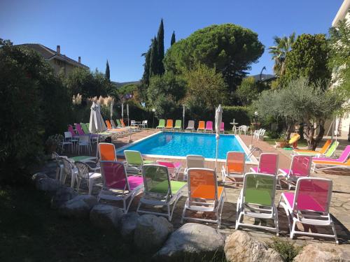 un grupo de sillas de jardín junto a una piscina en Le Villette di Villa Paola en Loano