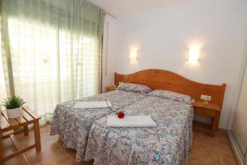 a bedroom with a bed with a red rose on it at COSTA DAURADA APARTAMENTS - Colibri Beach in Cambrils