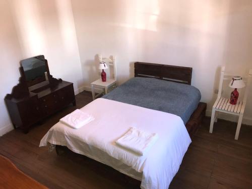 a bedroom with a bed and a tv and two tables at House in San Antonio de Areco