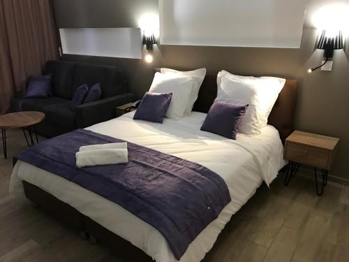 a bedroom with a large bed and a couch at Diamant les bains - Résidence Hôtelière in Le Diamant