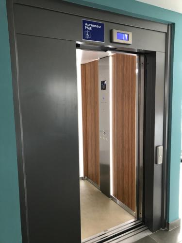 an elevator door in a building with a sign on it at Diamant les bains - Résidence Hôtelière in Le Diamant