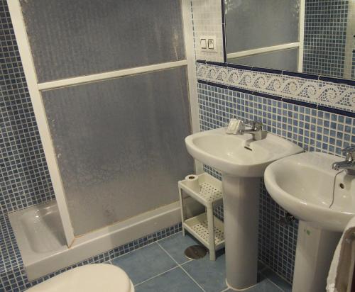 a bathroom with a shower and a sink and a toilet at Hostal Fantoni in Cádiz