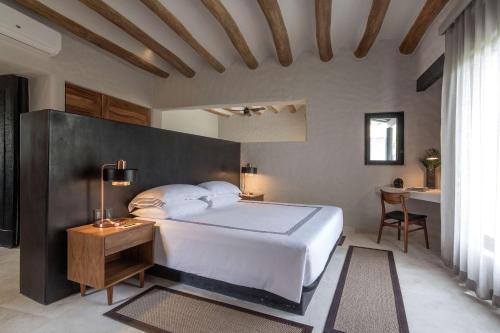 a bedroom with a large white bed and a desk at Thompson Zihuatanejo, A Beach Resort, by Hyatt in Zihuatanejo