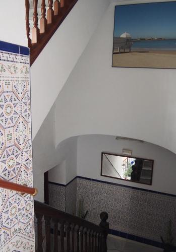 a staircase with a tv on the wall and a stair case at Hostal Fantoni in Cádiz