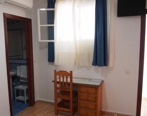 a room with a desk and a window and a chair at Hostal Fantoni in Cádiz