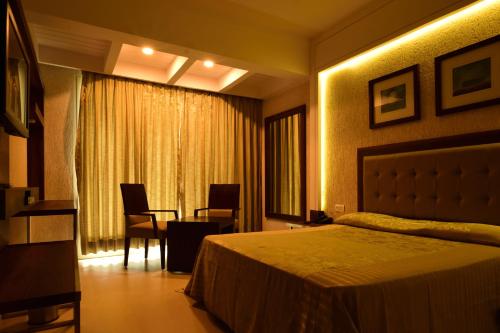 a hotel room with a bed and a table and chairs at Le Magnifique in Porvorim