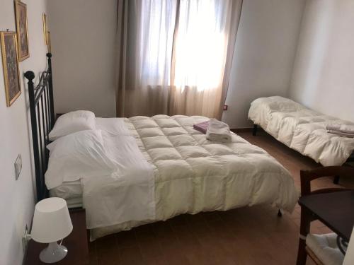 a bedroom with two beds and a window at Agriturismo La Vita è Bella in Fabriano