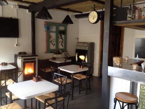 a restaurant with tables and chairs and a fireplace at Hotel Rio Piedra in Nuévalos
