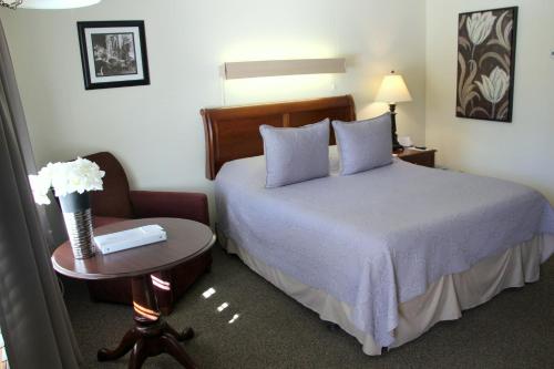 um quarto com uma cama, uma mesa e uma cadeira em All Seasons Inn em Oswego