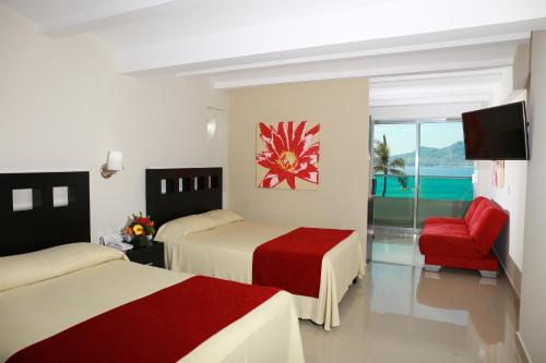 a hotel room with two beds and two tables at Las Flores Beach Resort in Mazatlán