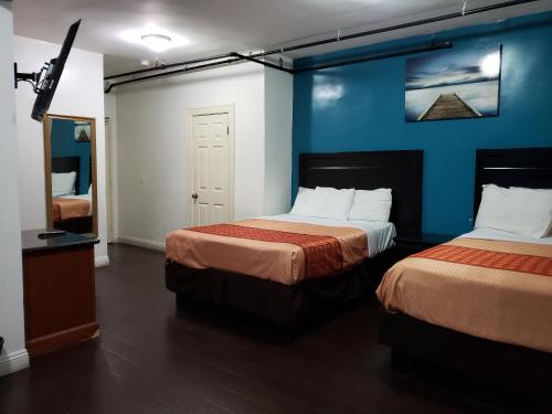Pokój z 2 łóżkami i niebieską ścianą w obiekcie Stuart Hotel w Los Angeles