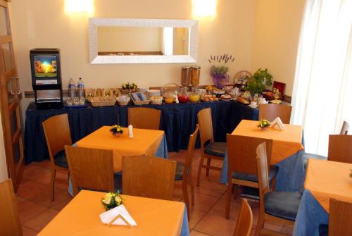 a dining room table with chairs and a television at Hotel Marzia in Scandicci