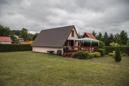 a small house with a gazebo in a yard at Domek Jantar in Jantar