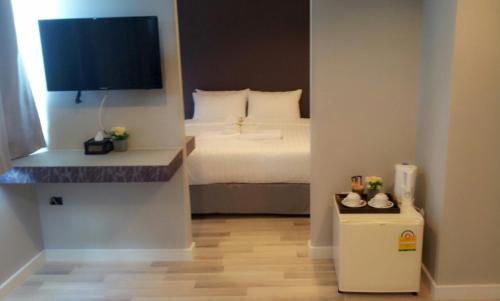 Habitación pequeña con cama y TV. en Nantra Ploenchit hotel en Bangkok