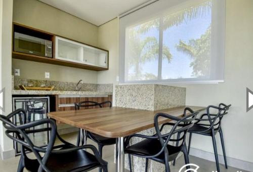 a kitchen with a wooden table and black chairs at Malai Manso Cotista - Resort Acomodações 8 hosp in Retiro