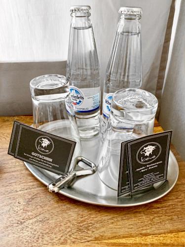 a tray with two bottles and glasses on a table at Hotel Akazienhof in Duisburg