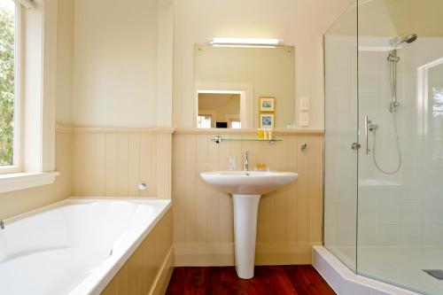 a white bathroom with a sink and a shower at Braestone Lodge in Dunedin