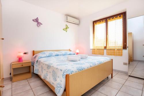 a bedroom with a bed and a table and a window at Villino Bilo Centro in San Teodoro