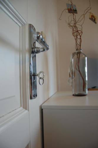 a water faucet on a wall next to a vase with flowers at Privatquartier 73 in Wietzen